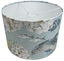 Load image into Gallery viewer, Light blue lampshade adorned with underwater motifs of jellyfish, fish, and other marine life.