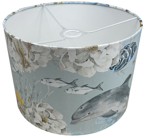 Light blue lampshade adorned with underwater motifs of jellyfish, fish, and other marine life.